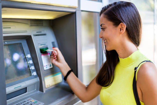 Woman withdrawing money at the ATM stock photo