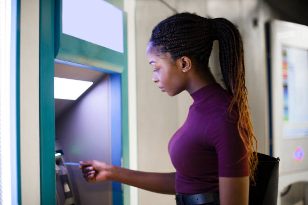 Woman withdrawing money from a cash machine Woman withdrawing money from a cash machine banks and atms stock pictures, royalty-free photos & images