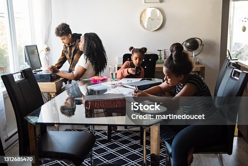 istock Woman working from home in small space with children around. 1312685470