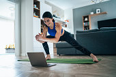 Fit woman doing side lunges indoors in a flat