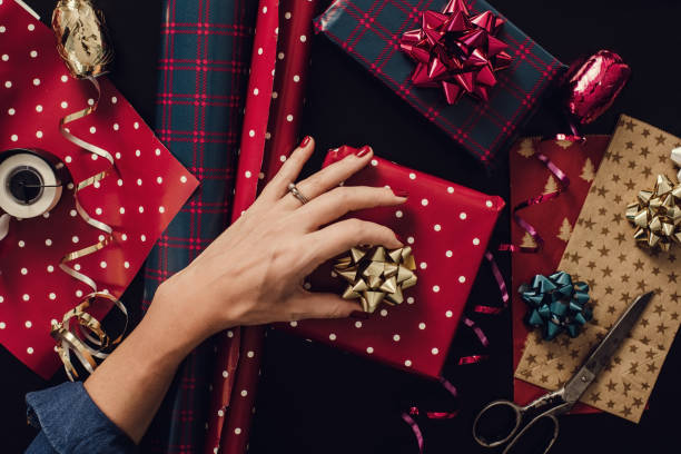 Woman wrapping christmas gifts presents photo taken from above overhead stock photo