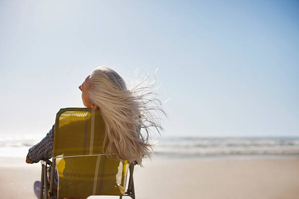 womans pelo soplando en el viento en la playa - cabello gris fotografías e imágenes de stock