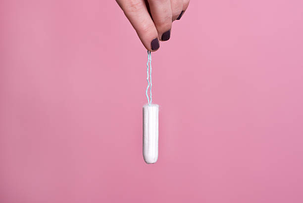 woman's hand holding a clean cotton tampon - tampons stockfoto's en -beelden