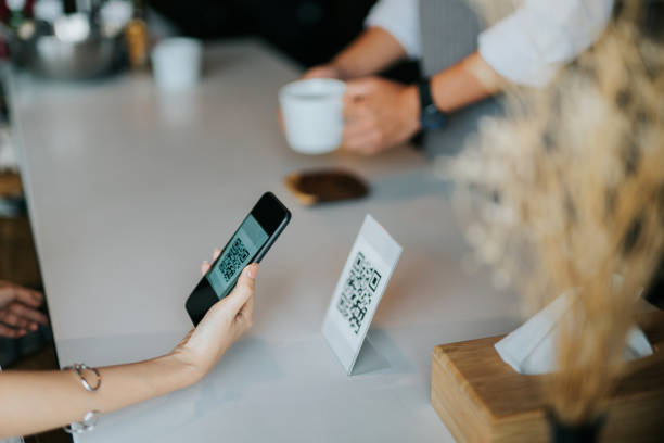 女人的手拿著智慧手機,在咖啡館掃描非接觸式付款的條碼 - qr code 個照片及圖片檔