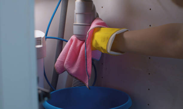 Woman's hand screwing the current syphon Close up woman's hands screwing the current syphon and wiping the water with a rag. Water flowing from a siphon under the kitchen sink. Plumbing in need of repair. Housekeeping siphon stock pictures, royalty-free photos & images