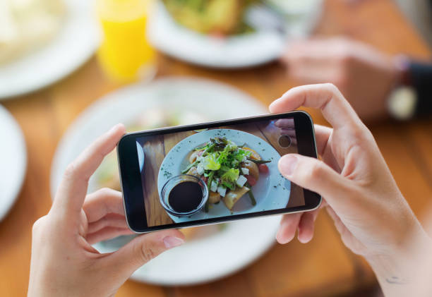 Woman's hands photograph her meal with her mobile phone Woman's hands use a cell phone to shoot her salad. food photos stock pictures, royalty-free photos & images