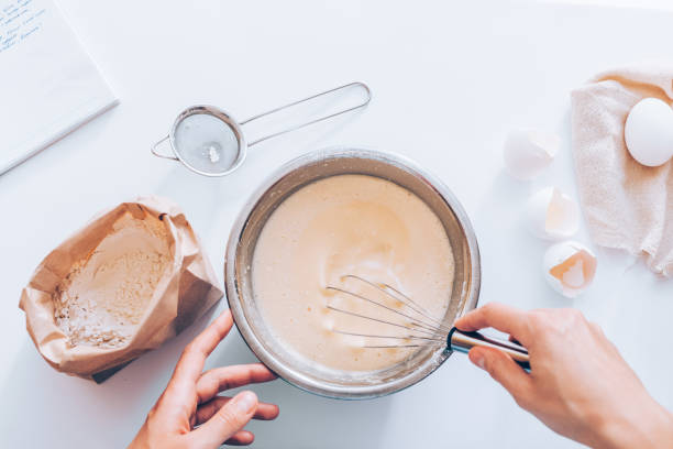 woman's hands whipping eggs and flour - misturar imagens e fotografias de stock