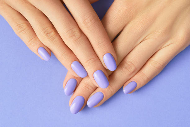 Womans hands with fashionable very peri manicure. Spring summer nail design stock photo