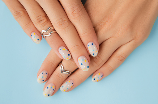 Womans hands with trendy polka dot summer manicure. Beauty treatment spa body care concept