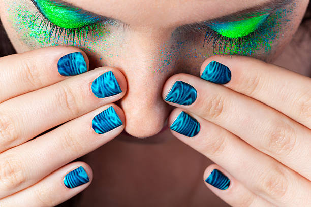Woman's lips with beautiful multicolor Minx nails and make-up stock photo