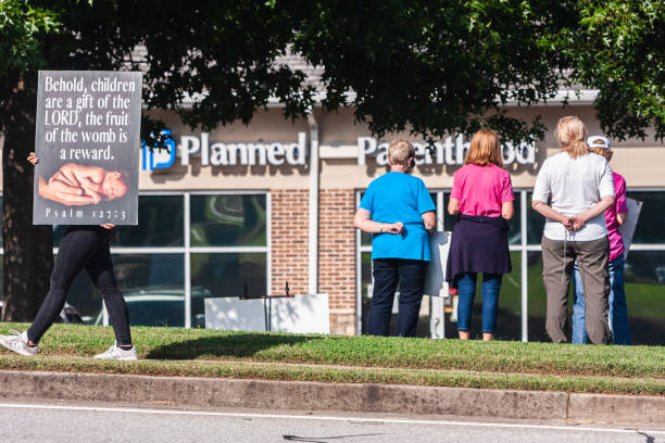 Women Against Abortion Stand Outside A Georgia Planned Parenthood Clinic Lawrenceville, GA - October 9 2021:  Several women against abortion  stand and glare outside a Planned Parenthood clinic  on October 9, 2021 in Lawrenceville, GA. abortion clinic stock pictures, royalty-free photos & images