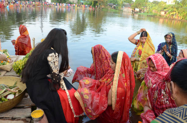 Women and men worshiping Hindu god at river Ganges in kolkata on the occasion of chhath puja festival. Indian women waiting for sunrise on the occasion of chhath puja festival. Chhath is a Hindu festival celebrated each year by the people very eagerly. This is very antique festival of the Hindu religion dedicated to the God of energy, also known as Dala Chhath chhath stock pictures, royalty-free photos & images