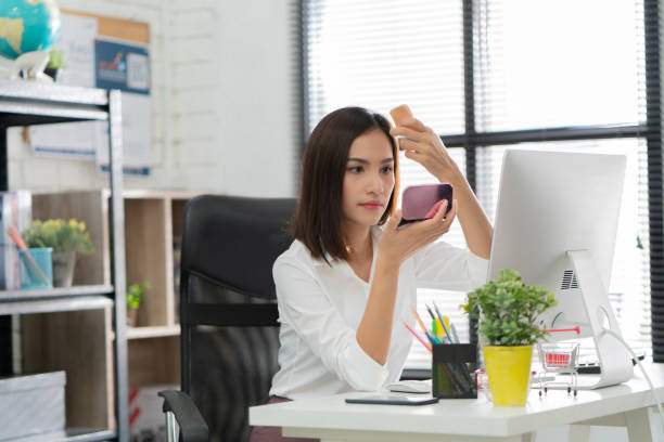 Women are making up at her office during work. stock photo
