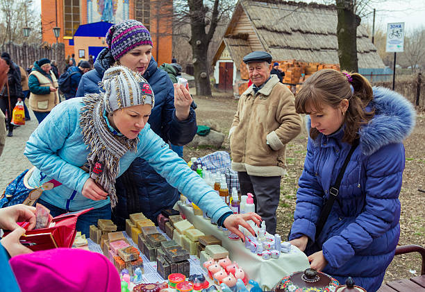 Women choosing cream during Shrovetide Celebration in Zaporizhia Zaporizhia/Ukraine- March 13, 2016: Women choosing cream on the stand with natural cosmetics and handmade soap of a street trader during Shrovetide (Pancake Week) Celebration in the city park zaporizhzhia stock pictures, royalty-free photos & images
