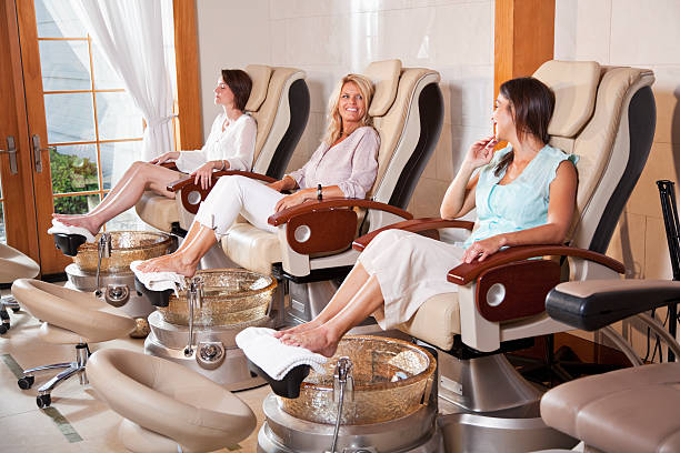 Women getting pedicures Mature women (40s) at beauty spa getting a pedicures. nail salon stock pictures, royalty-free photos & images