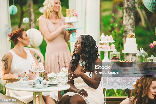 Women having a garden party with dessert table