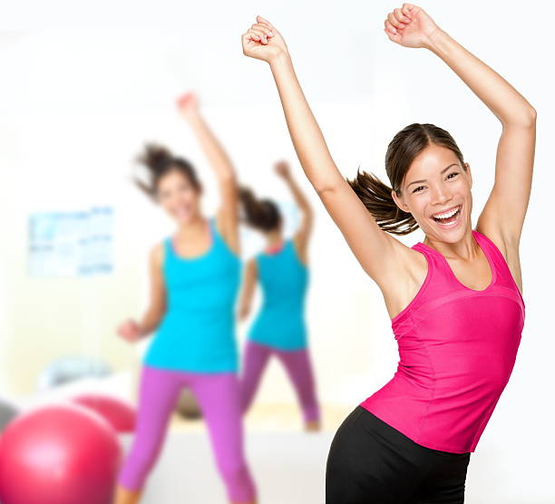 Women in pink and blue doing a Zumba dance stock photo