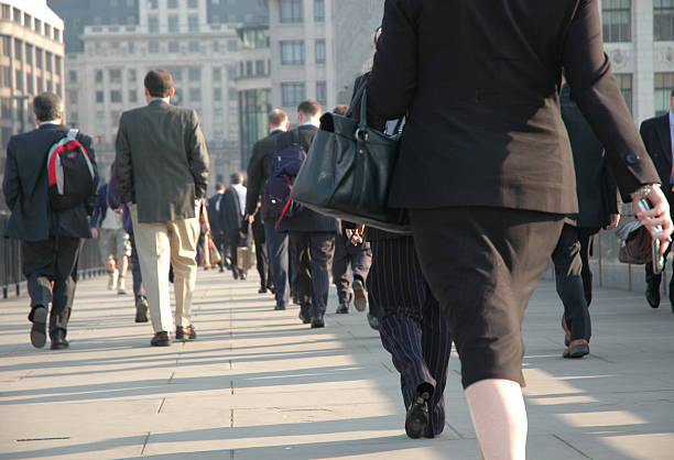 Women in the city Female worker in group of men arriving for work walking across London Bridge towards the financial district of the City of London, early morning, May 2006 gender stereotypes stock pictures, royalty-free photos & images