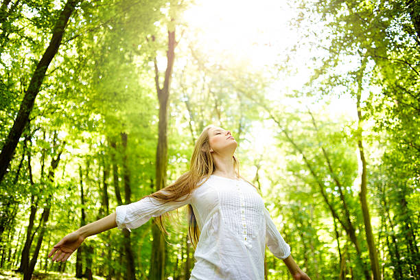 A women in the woods basking in the sun stock photo