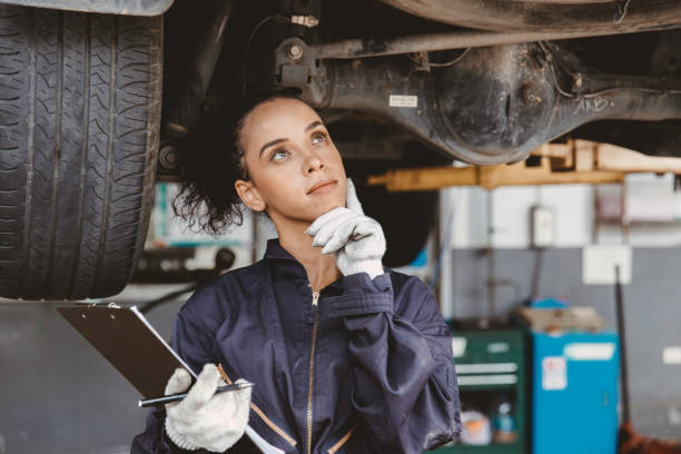 Women mechanic worker thinking. Garage staff female think day dream or forget check list auto service. stock photo