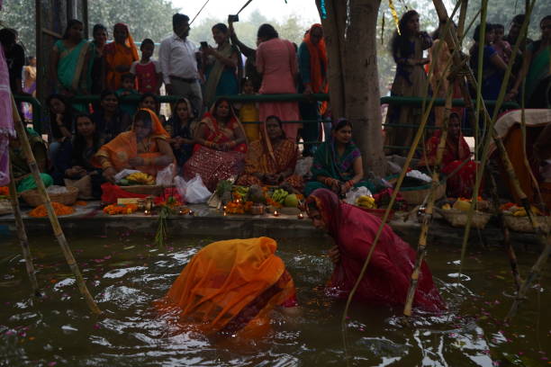 Women of India celebrating Chhath Pooja by drowning themselves in Water for praying to sun. New Delhi, Delhi/ India- October 24 2020 : Women of India celebrating Chhath Pooja by drowning themselves in Water for praying to sun. chhath stock pictures, royalty-free photos & images