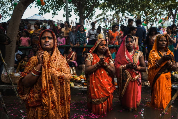 Women of India celebrating Chhath Pooja New Delhi, Delhi/ India- November 02 2019 : Women of India celebrating Chhath Pooja by drowning themselves in Water for praying to sun. chhath stock pictures, royalty-free photos & images