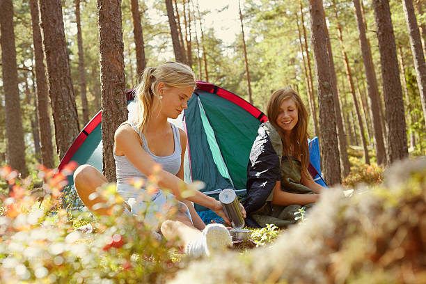 Women setting up campsite in forest  swedish girl stock pictures, royalty-free photos & images