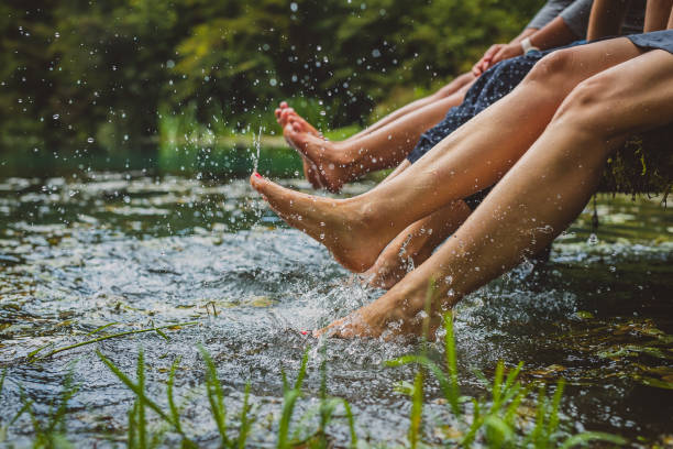 women splashing feet in water stock photo