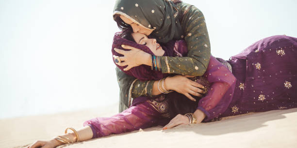 Women thirsty in a desert. Unforeseen circumstances during the travel Desert women thirsty dehydrated lying on sand outdoors. Dehydration, overheating, thirst and heat stroke concept image with two sisters in desert nature.Portrait of two beautiful mixed race asian caucasian arabian girls lost in desert during journey. hot arabic girl stock pictures, royalty-free photos & images