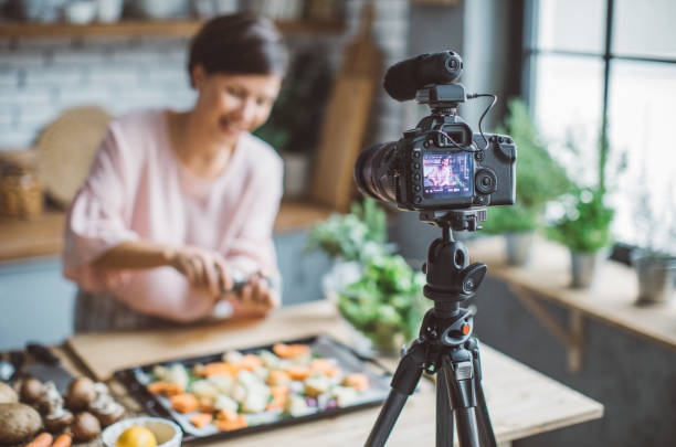 Women vlogging Mid adult woman vlogging in her kitchen. goose meat photos stock pictures, royalty-free photos & images
