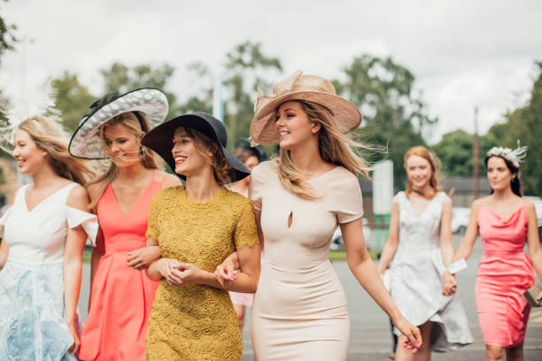 Women Walking to Racecourse Young women walking towards the entrance for the horse race course. dress stock pictures, royalty-free photos & images