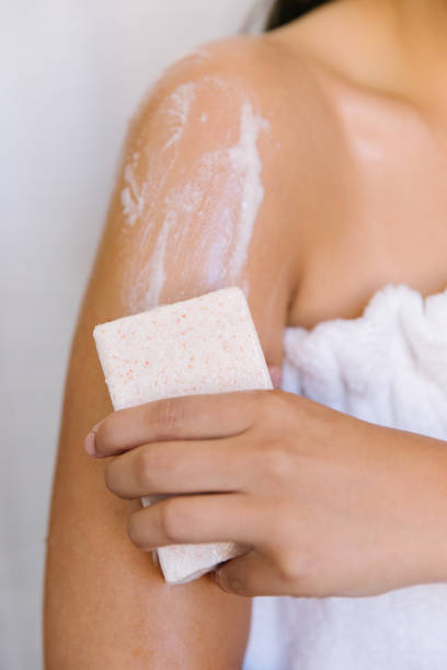 A women washing her arm with a bar of soap. stock photo
