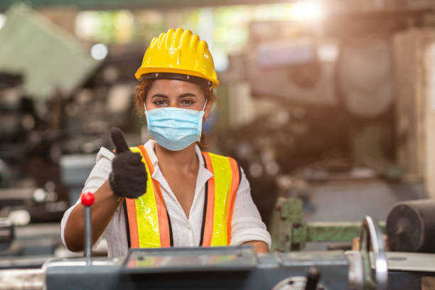 Women worker wear disposable face mask for protection Corona Virus Spreading and smoke dust air pollution filter in factory for healthy labor care. Women worker wear disposable face mask for protection Corona Virus Spreading and smoke dust air pollution filter in factory for healthy labor care. blue collar worker photos stock pictures, royalty-free photos & images