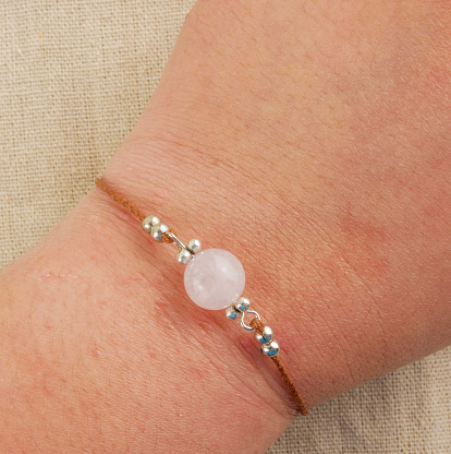 Close up wrist wearing rose quartz gemstone bracelet