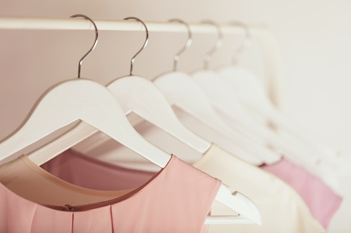 Women's clothing in pink tones on a white hanger. Selective focus.