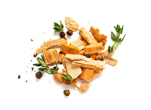 Chips for smoking meat and fish isolated on white background. Piles of wood chips with thyme and pepper top view