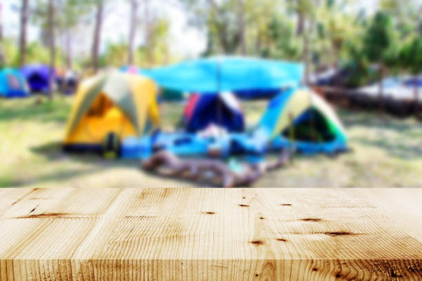 木製のテーブルとぼやけたキャンプと森のテント。 - wood table ストックフォトと画像