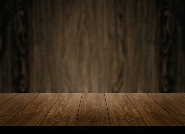 木製の壁のぼかしの背景の前に木製のテーブル。 - wood table ストックフォトと画像