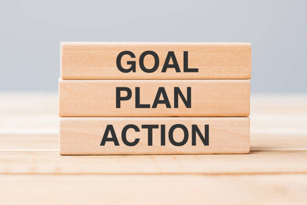 wooden block with GOAL, PLAN and ACTION on table background stock photo