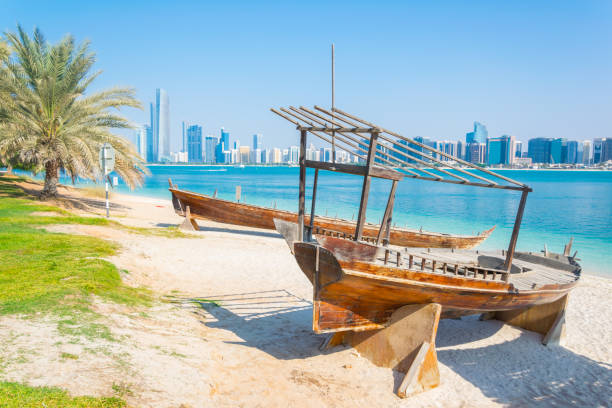 Wooden boat at the Heritage Village, in front of the Abu Dhabi skyline, United Arab Emirates Wooden boat at the Heritage Village, in front of the Abu Dhabi skyline, United Arab Emirates dhow stock pictures, royalty-free photos & images