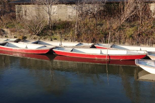 Wooden boats lined up along the other side of the river stock photo