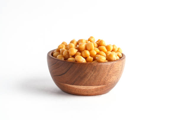 Wooden bowl of preserved (boiled) chickpea isolated on white background stock photo