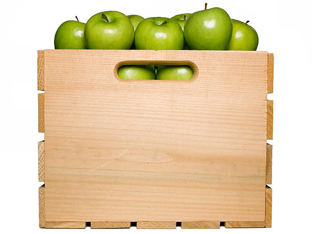 Wooden box full of green apples isolated on white stock photo
