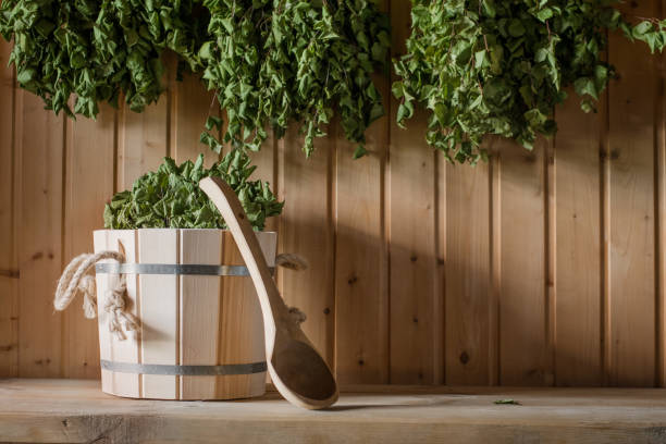 A wooden bucket and a birch broom in a Russian bath. Sauna. stock photo
