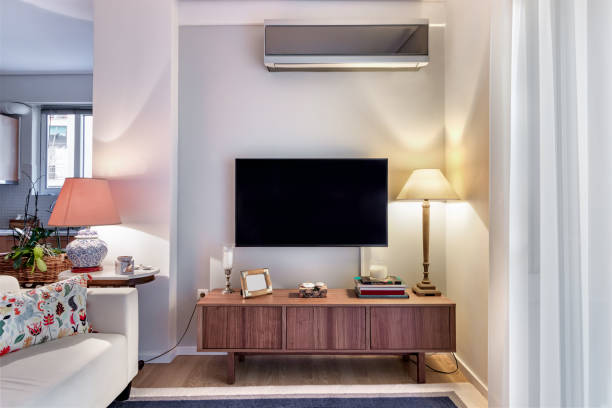 houten kast met platte tv en lampen op een kleine woonkamer. - ramos stockfoto's en -beelden