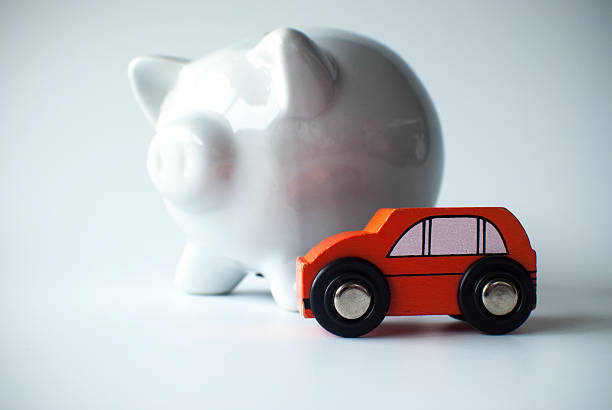 wooden car and piggy bank red orange wooden toy car and white piggy bank on white background for concept of a car loan car loan stock pictures, royalty-free photos & images