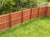 istock Wooden garden fence coated with medium oak colour paint 1325530417