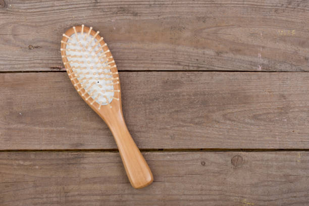 Wooden hairbrush, comb for hair on brown wooden background stock photo