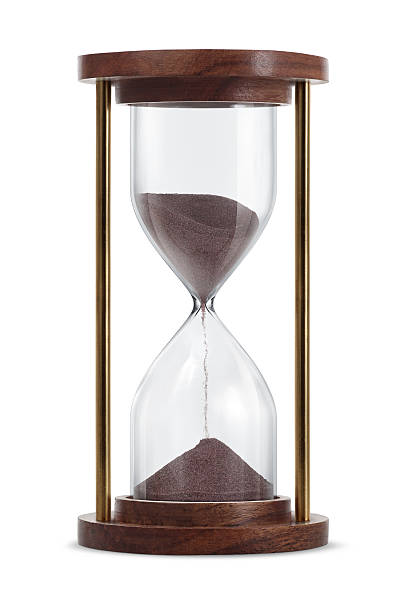 Wooden hourglass with brown sand running through it stock photo