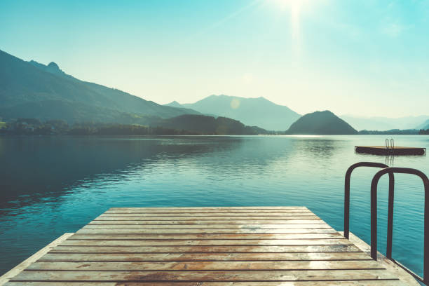 Wooden jetty for swimming Wooden jetty for swimming in mountain lake in Austria. Swimming at early morning. European resort in mountains lake stock pictures, royalty-free photos & images